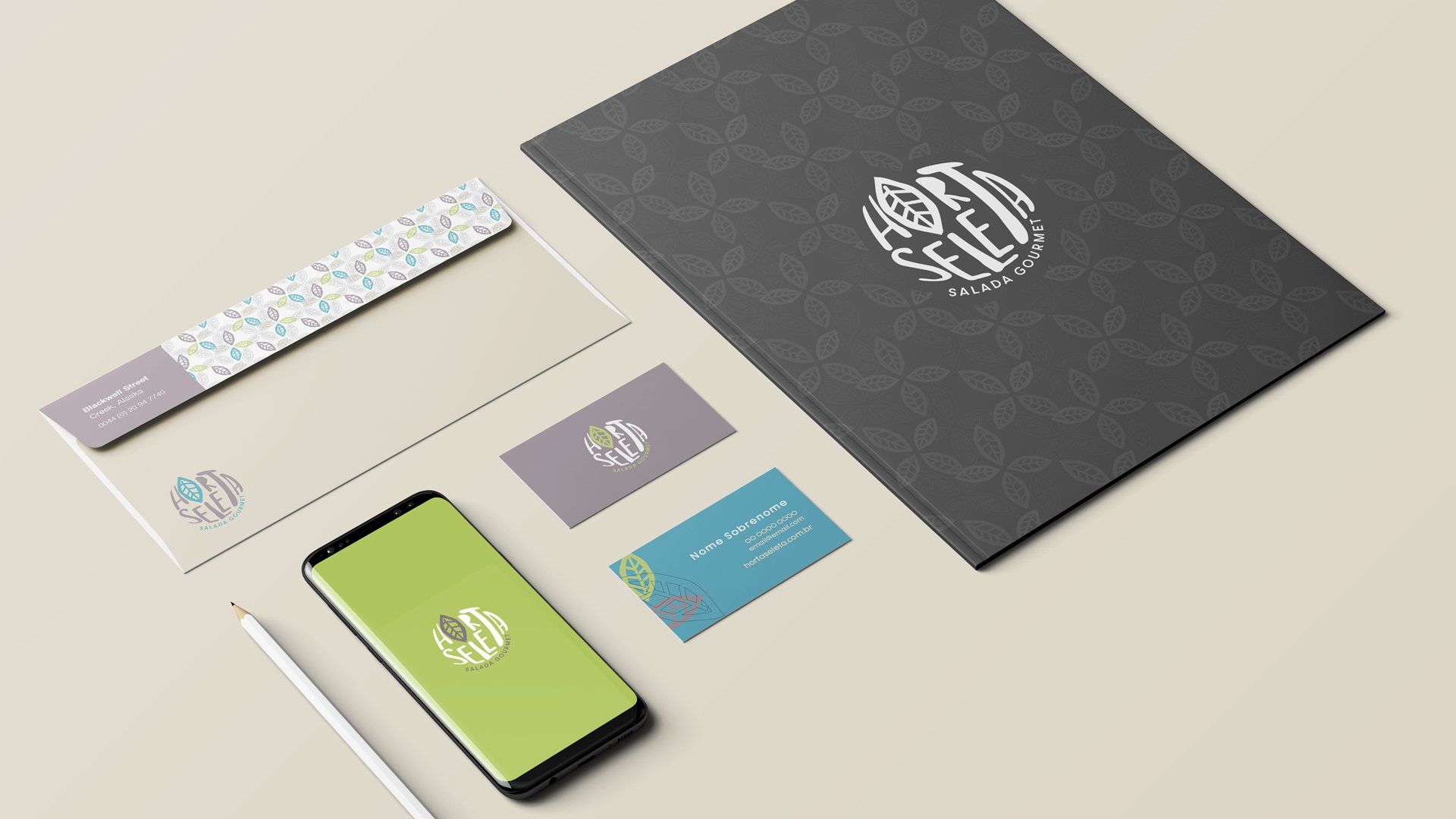 Modelo de papelaria com uma pasta cinza escura, cartões de visita, envelope, telefone e lápis, todos com um logotipo.