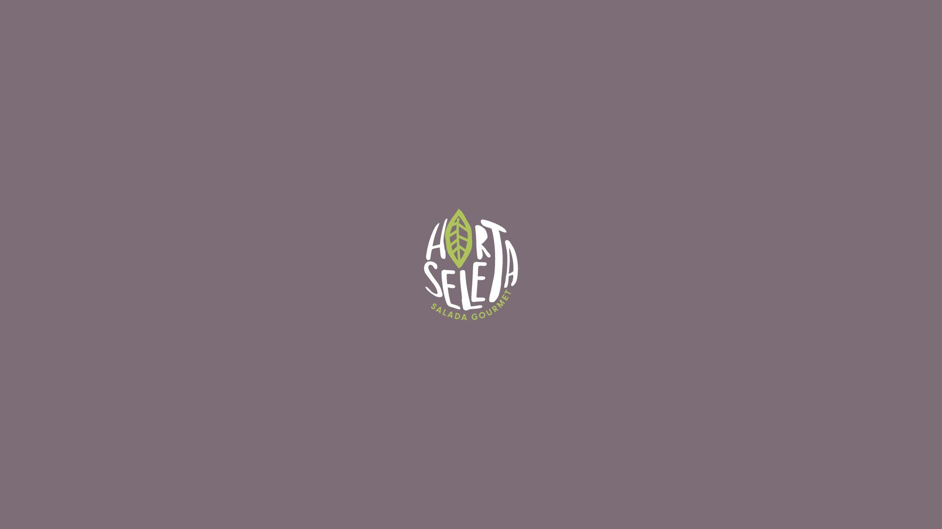 Logotipo com texto branco no formato de uma ameixa com uma folha verde sobre fundo roxo escuro. Diz