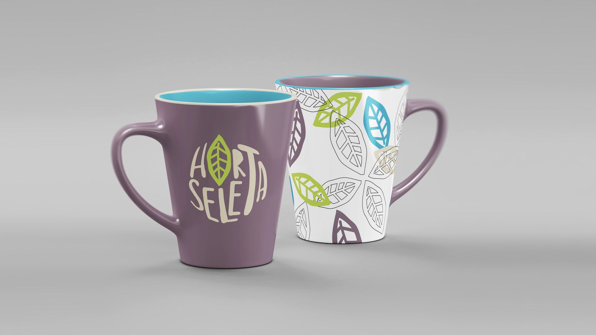 Duas canecas de cerâmica, uma roxa com um logotipo e a outra branca com padrões de folhas.