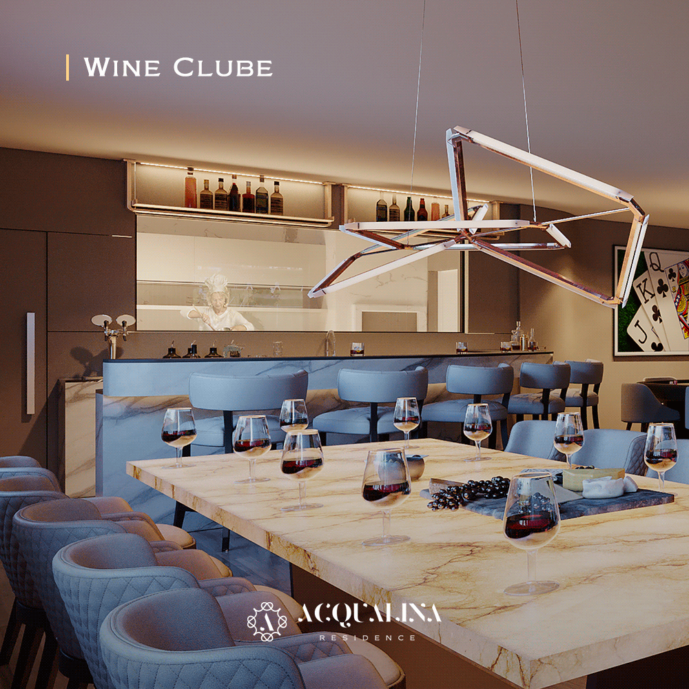 Sala de jantar do Wine Club com uma longa mesa de mármore posta para convidados e um bar ao fundo. Tons de cinza e bege criam um ambiente sofisticado.