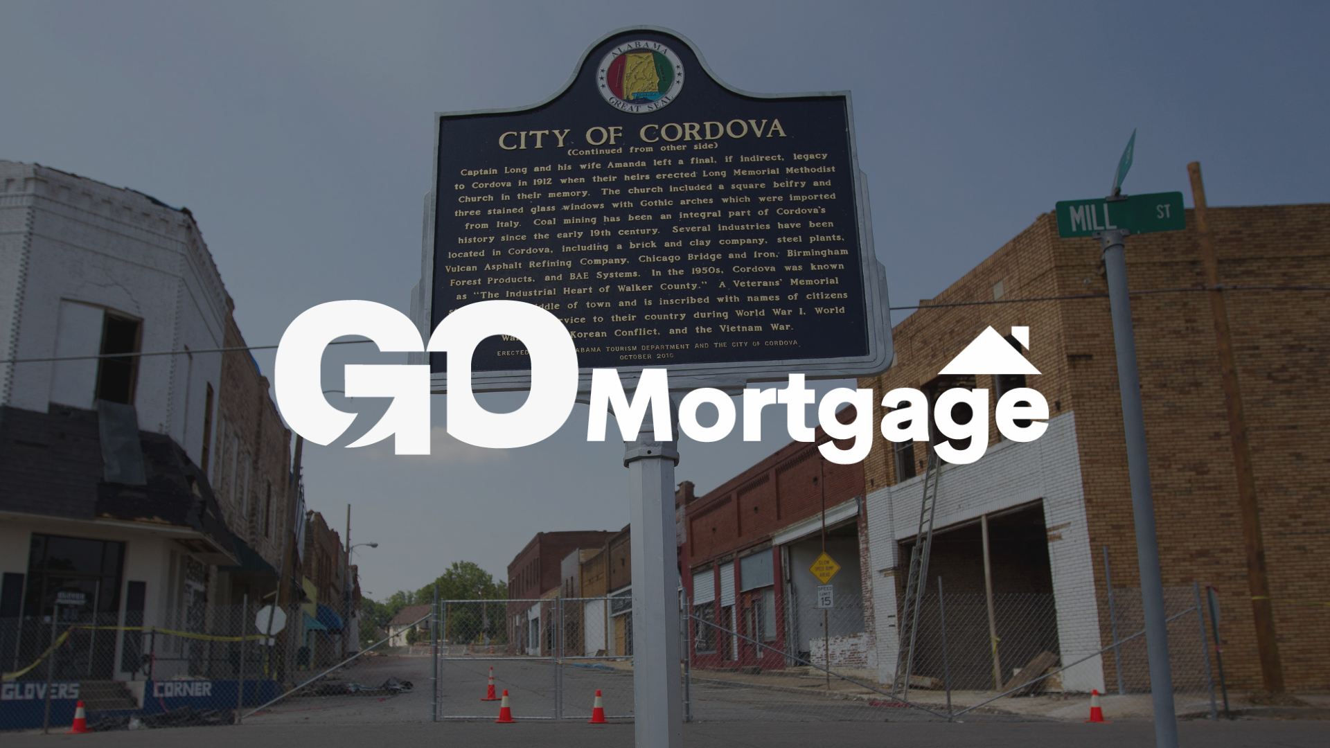 A sign that says city of cordova alabama go mortgage is in front of a brick building.