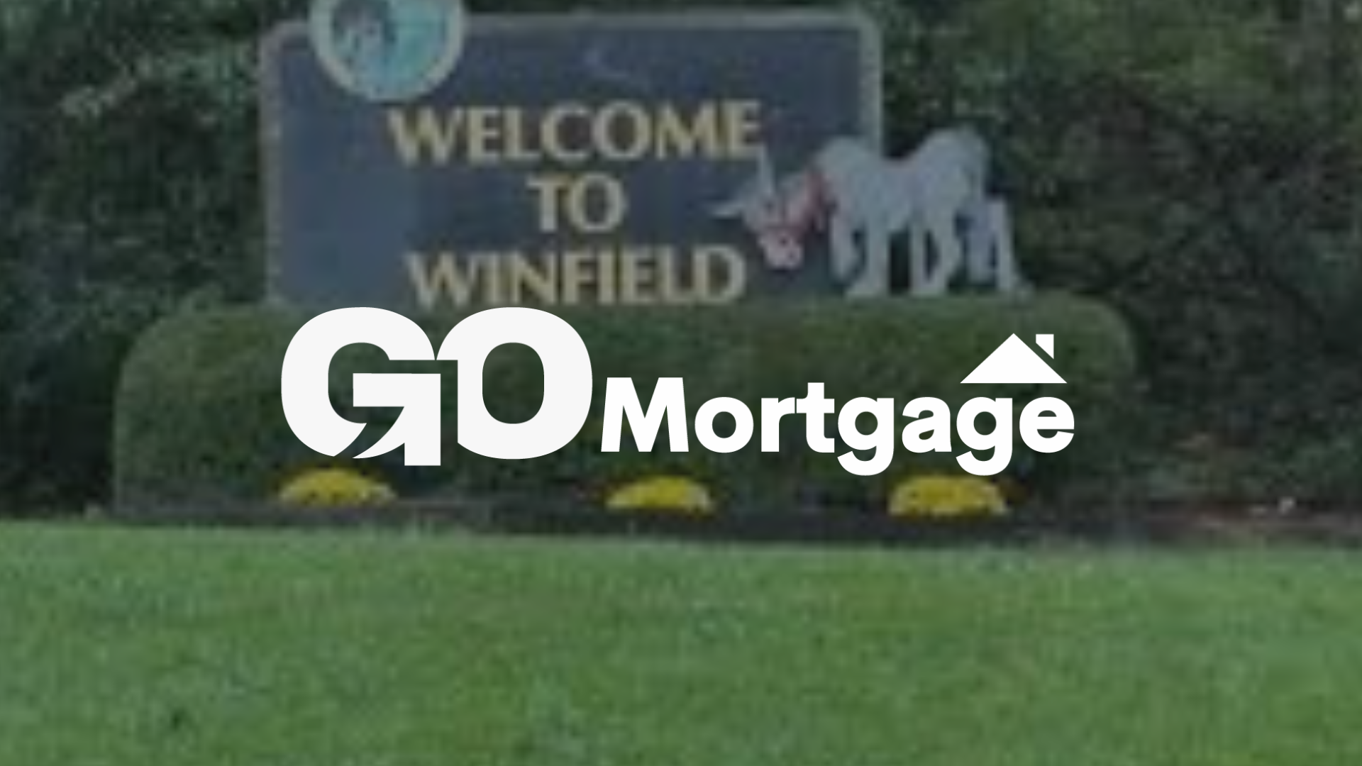 Welcome to Winfield sign with GO Mortgage logo overlaid. The sign has a horse statue.