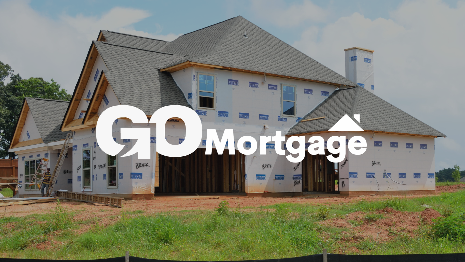 A house is being built in a field with the words go mortgage written on it.