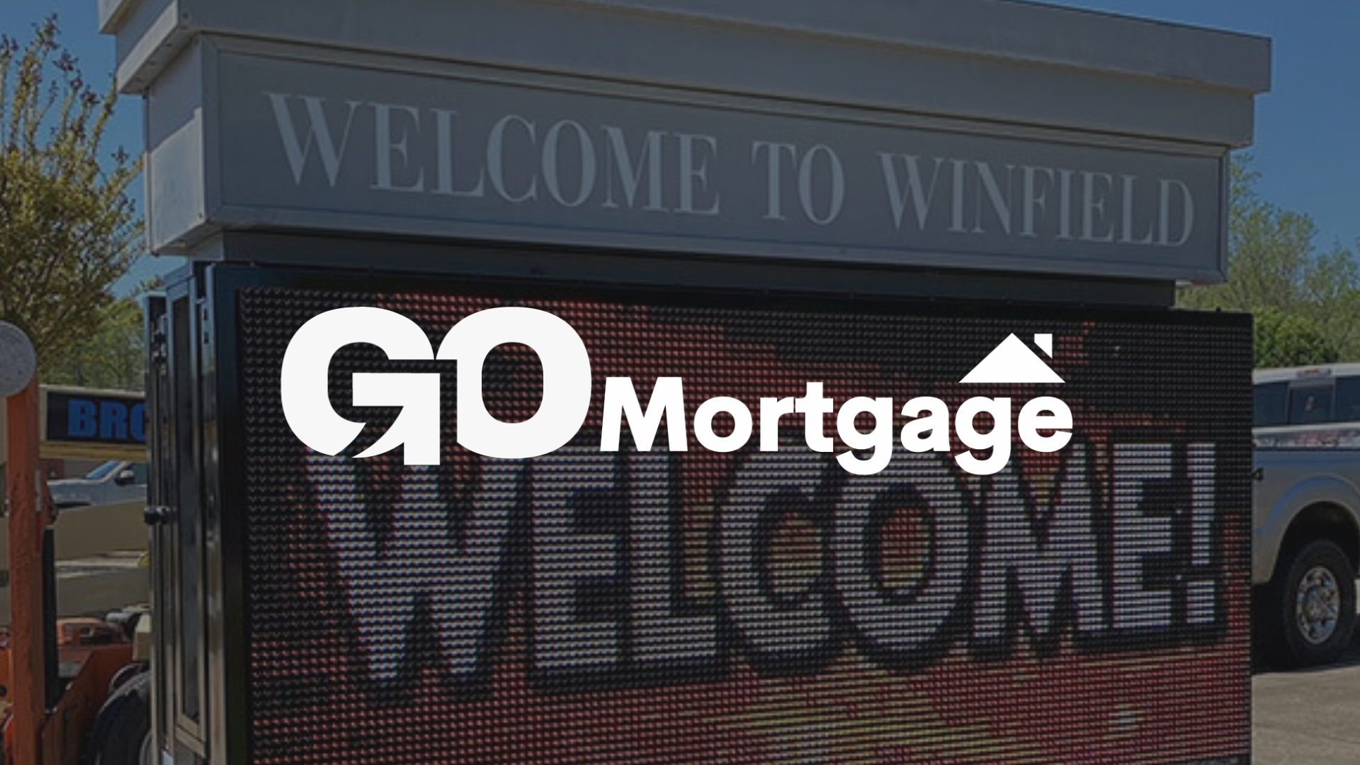 GO Mortgage advertisement on an electronic sign in Winfield, AL featuring a welcome message.