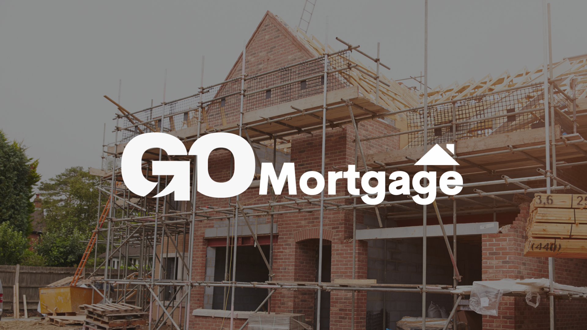 A brick house is being built with scaffolding around it with the go mortgage logo