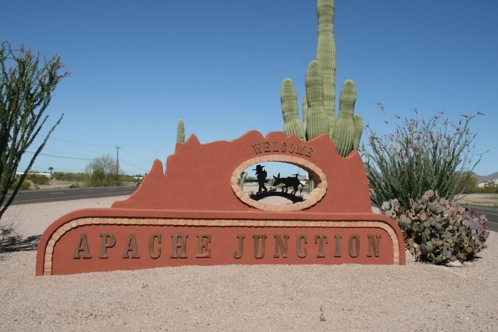 Sign for Apache Junction, Arizona. Red sign with desert scene silhouette.