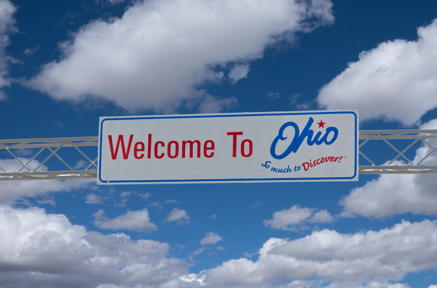 A welcome to ohio single close construction sign with a blue sky in the background