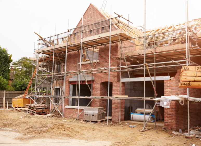 A brick house is being built with scaffolding around it.