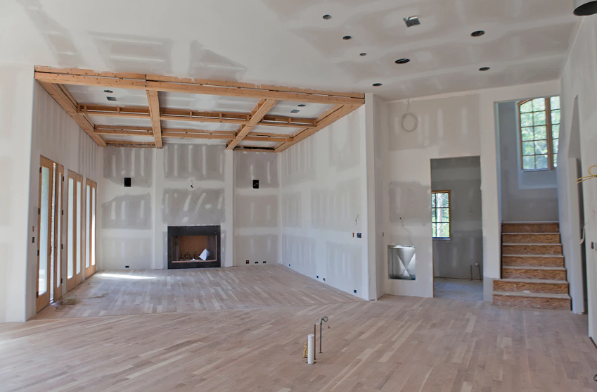 An empty room with a fireplace and stairs in it