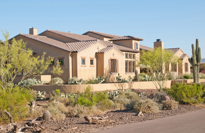 A large house is sitting in the middle of a desert.