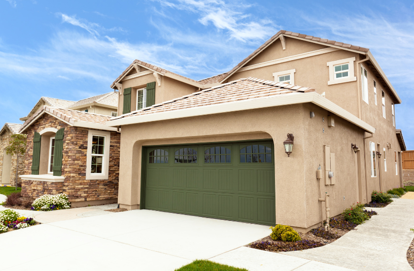 A large house with a green garage door.