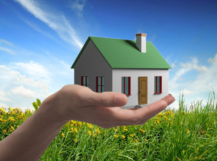 A person is holding a small house in their hand