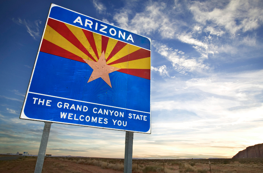 A blue sign that says arizona the grand canyon state welcomes you