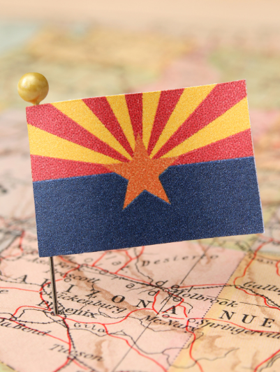 A small arizona flag is pinned to a map