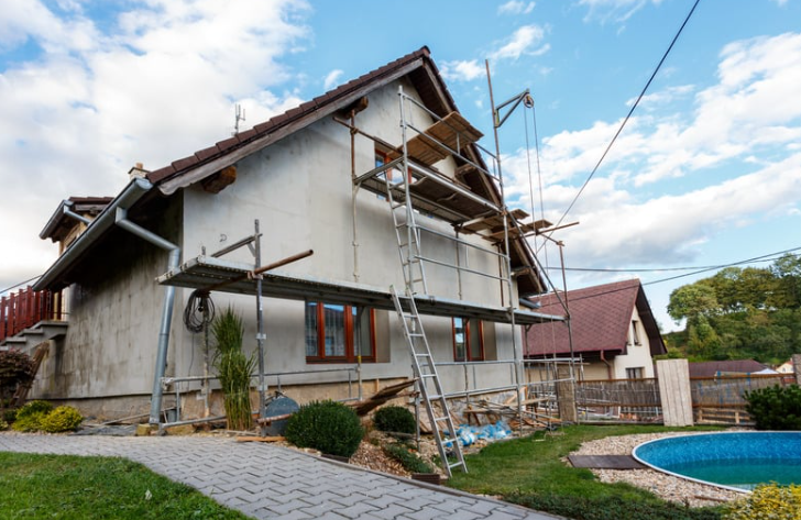 A house is being painted with scaffolding around it.