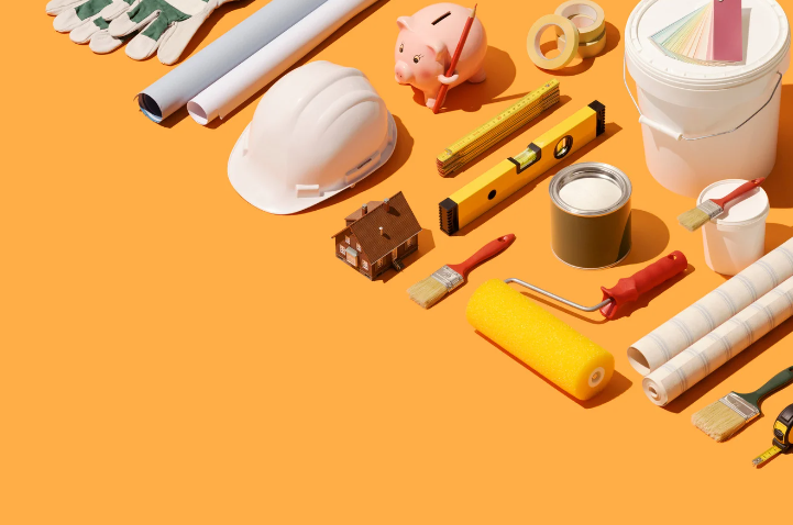 A bunch of construction tools and a piggy bank on an orange background.