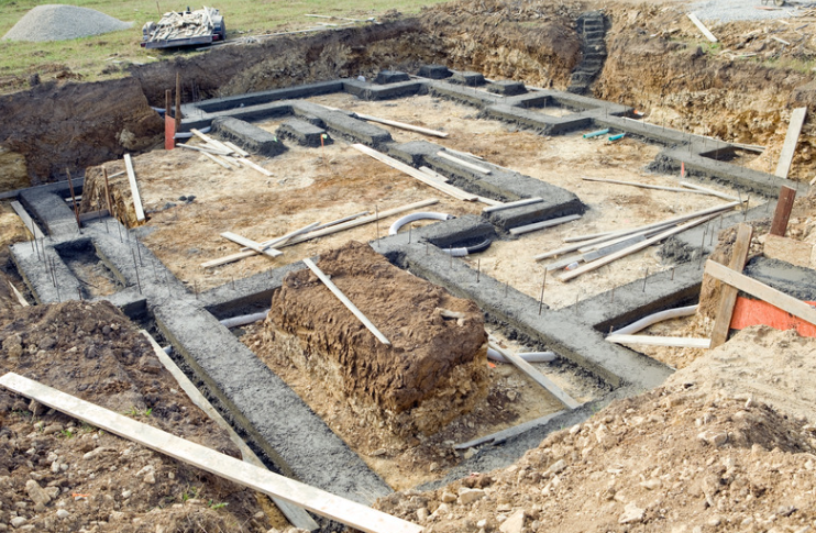 A foundation for a house is being built in a dirt field.