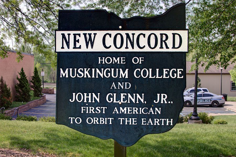 Sign for New Concord, Ohio, home of Muskingum College and John Glenn, Jr. The sign is shaped like the state of Ohio.