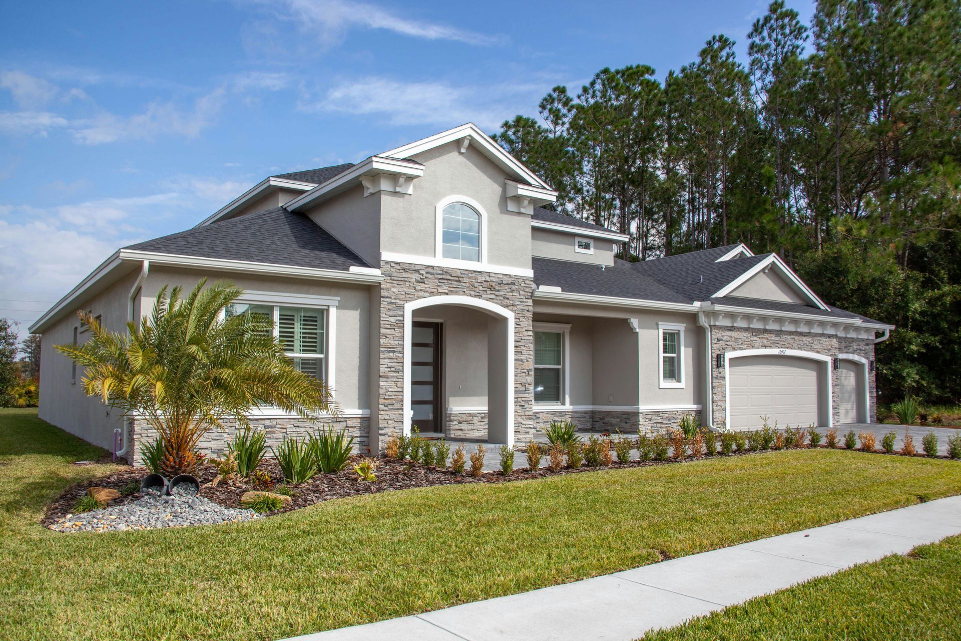 A large house with a lush green lawn and trees in the background