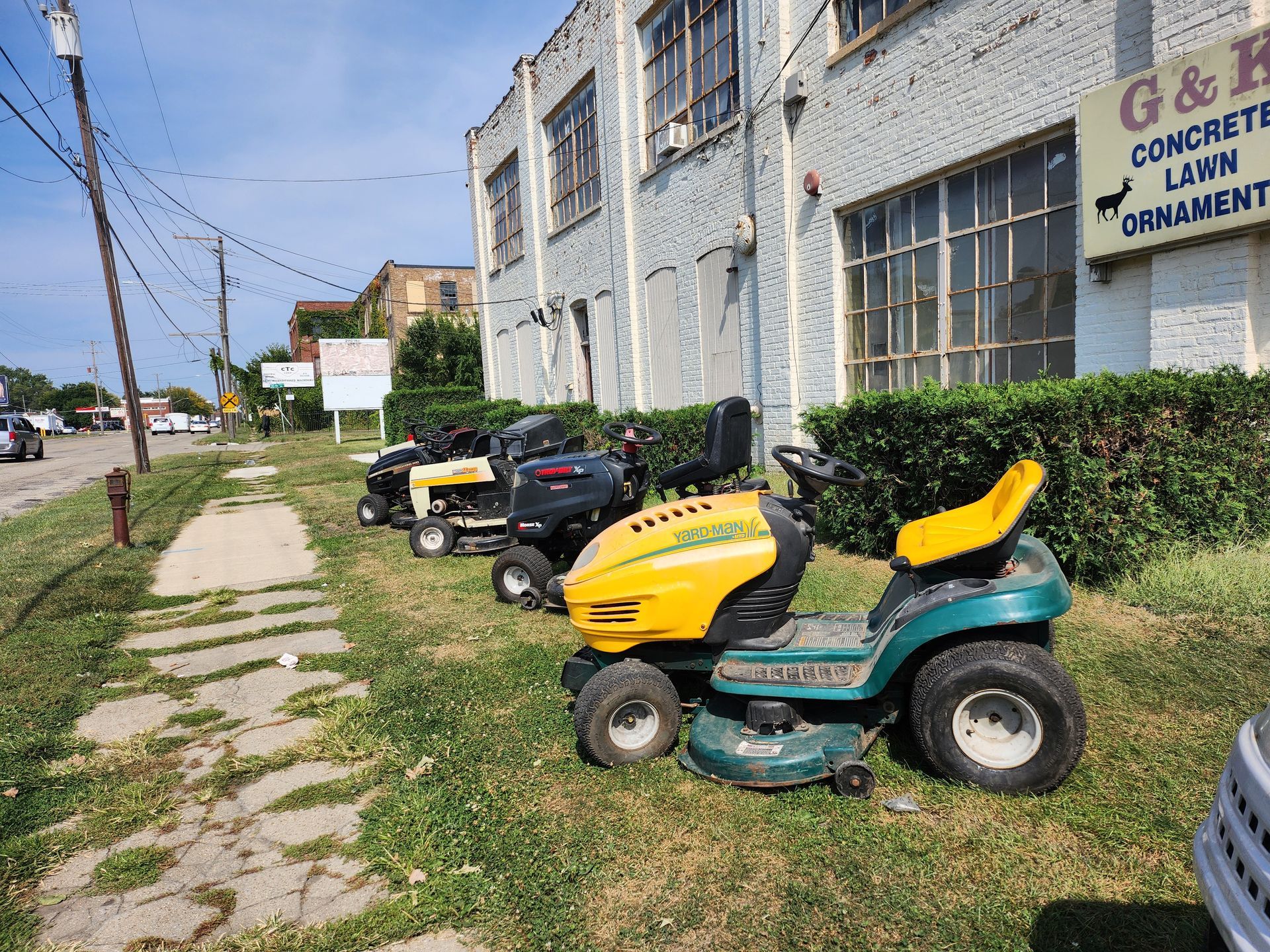 A red and black lawn mower is parked in the grass.