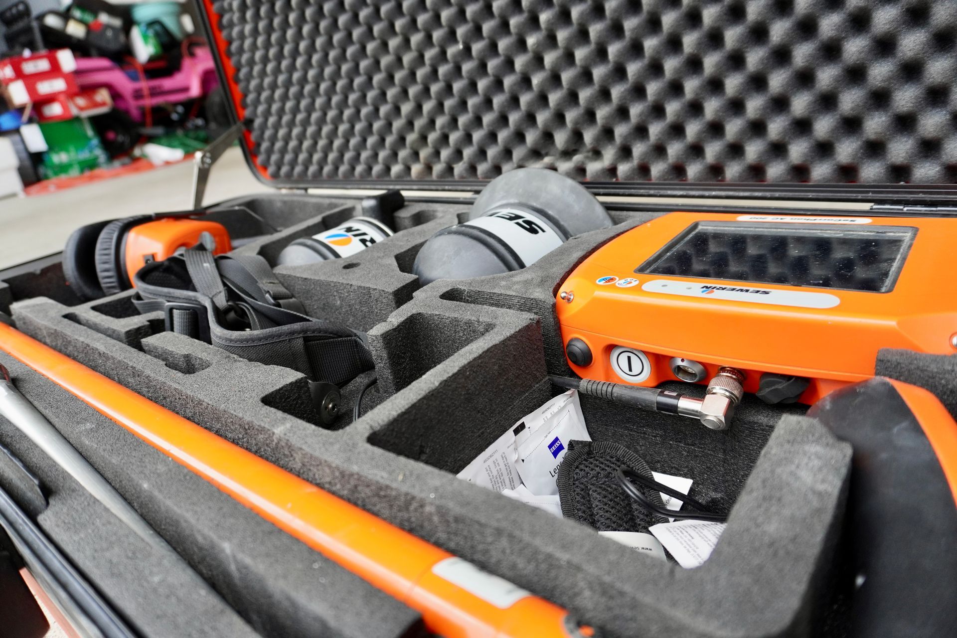 Orange case with equipment, including a detector, in molded foam.
