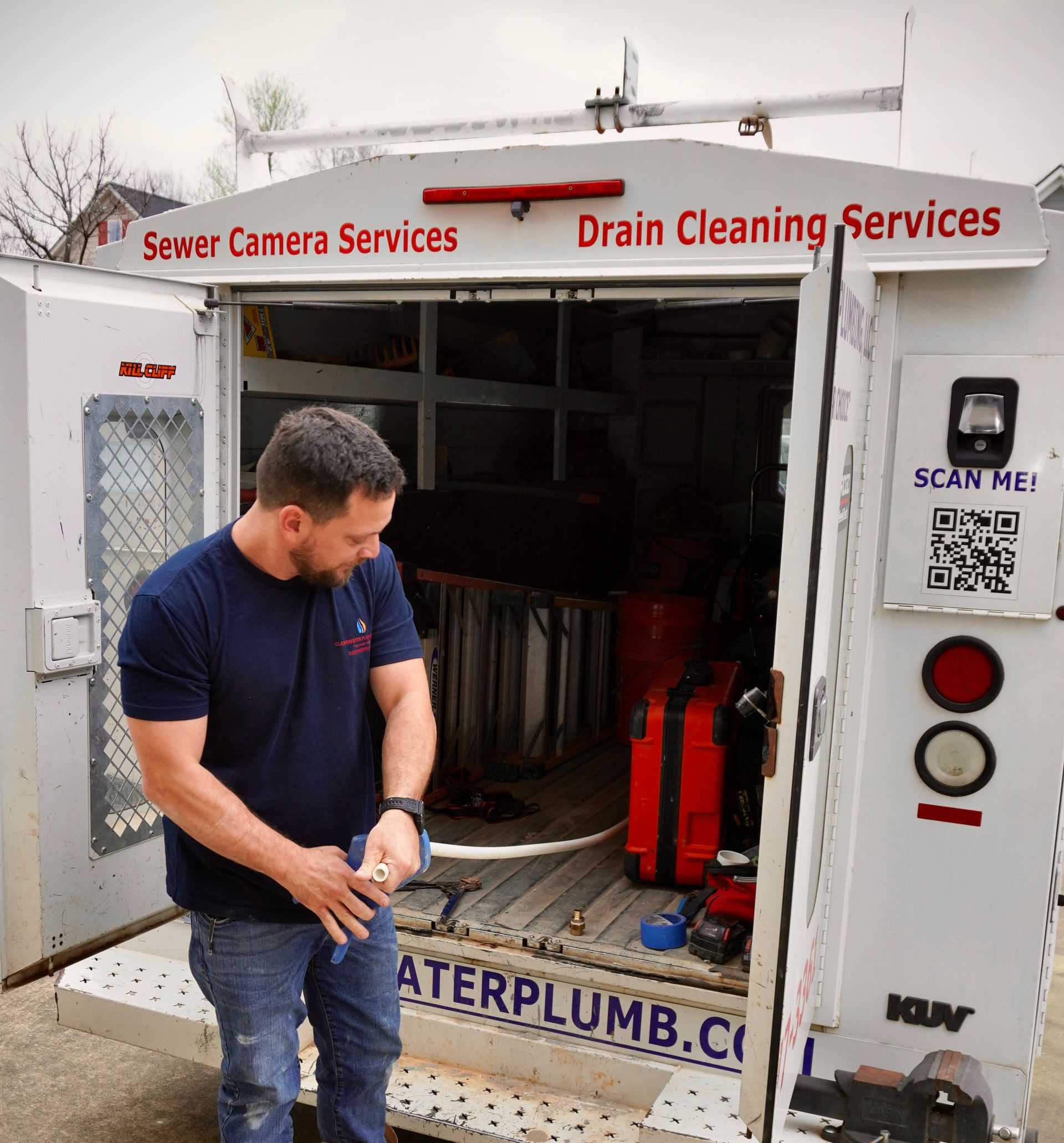 Man stands by an open service truck labeled 
