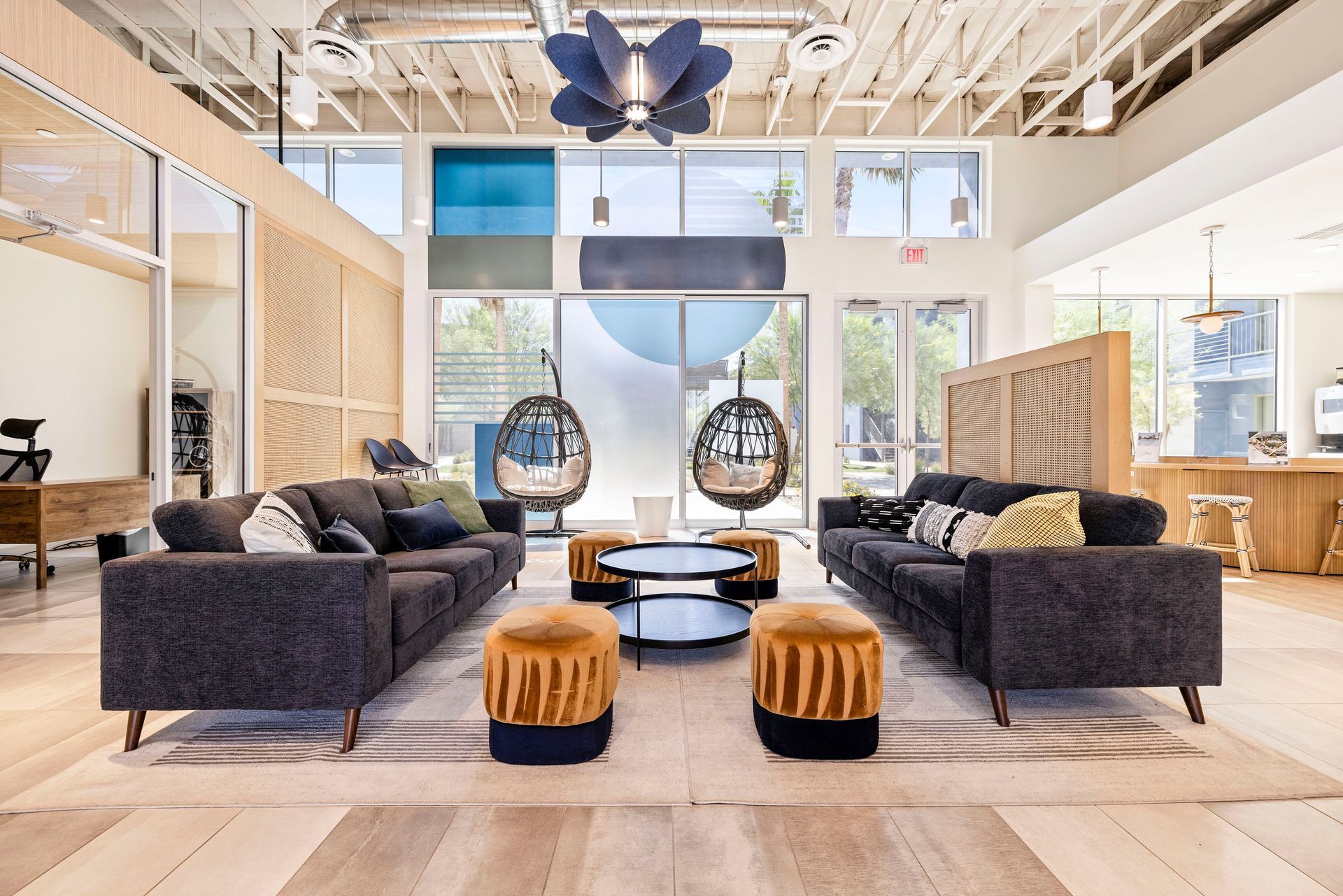 Modern lobby with couches, hanging chairs, and a large window.