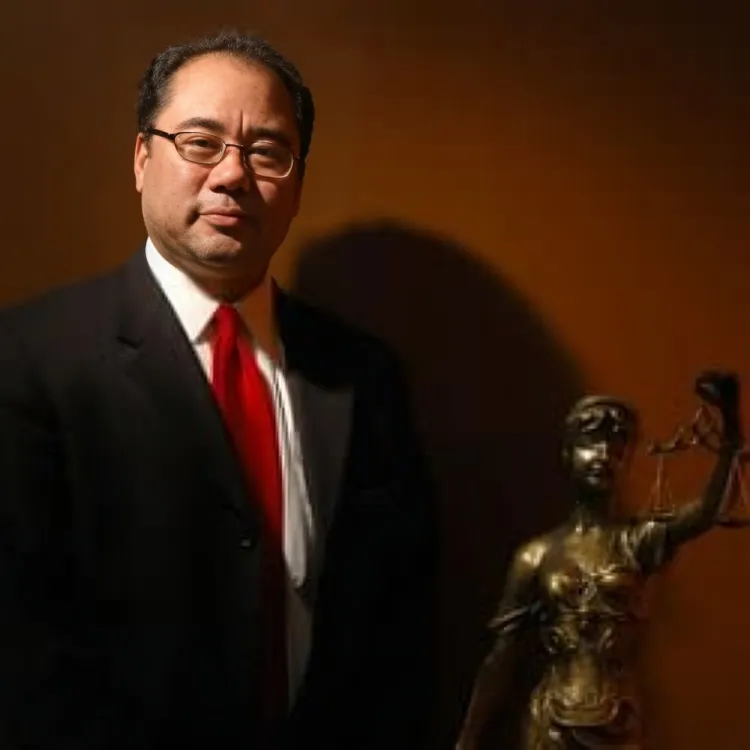 A woman in a black dress is standing on a bridge in front of a city skyline.