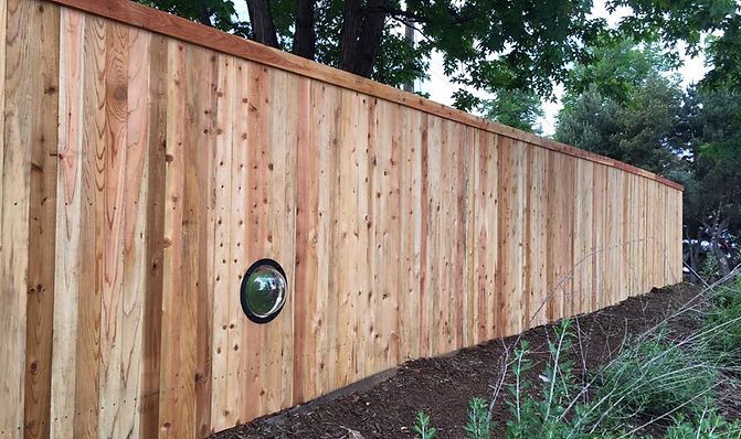 A wooden fence with a light on the side of it.