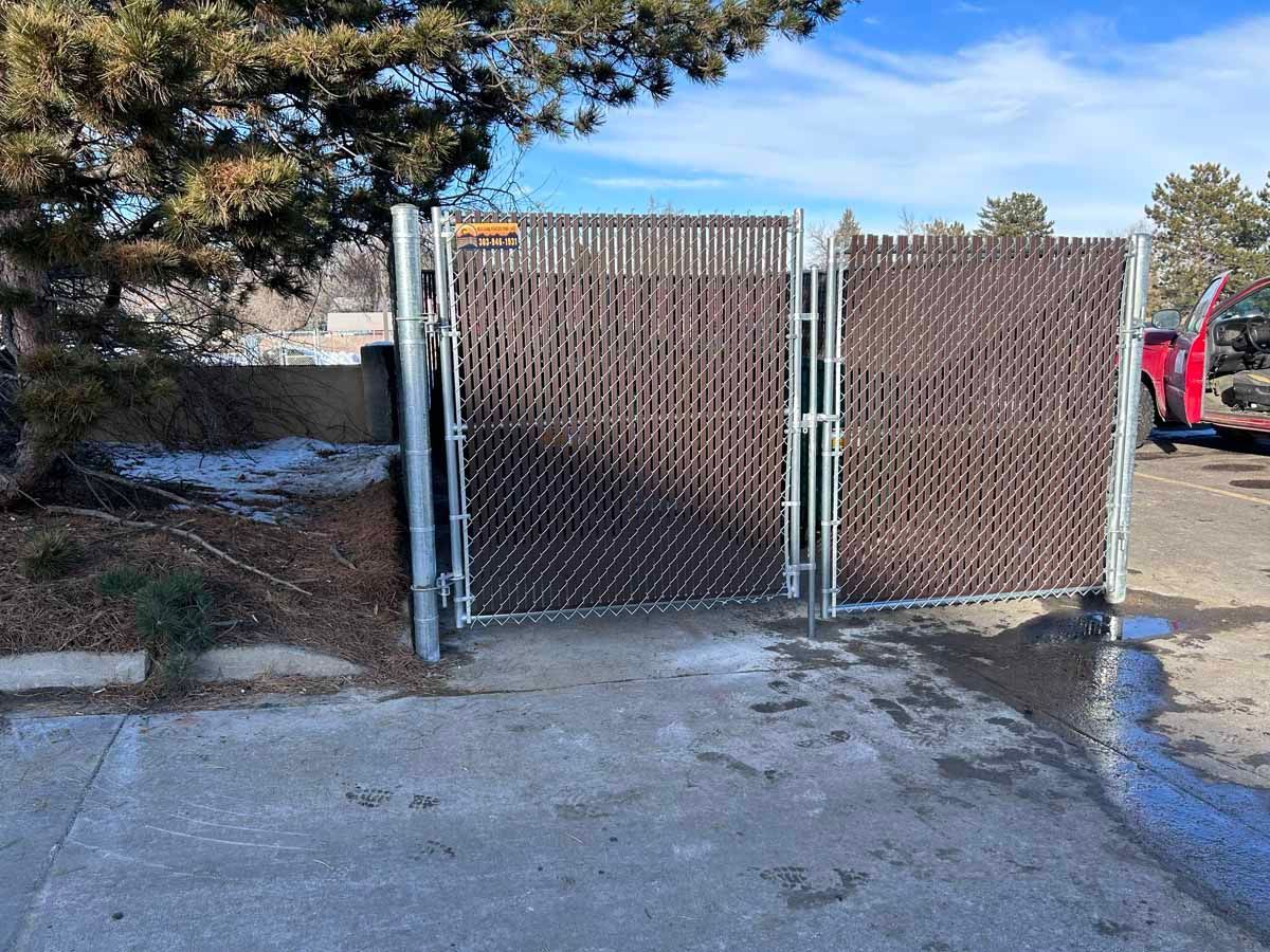A chain link fence is surrounding a parking lot.