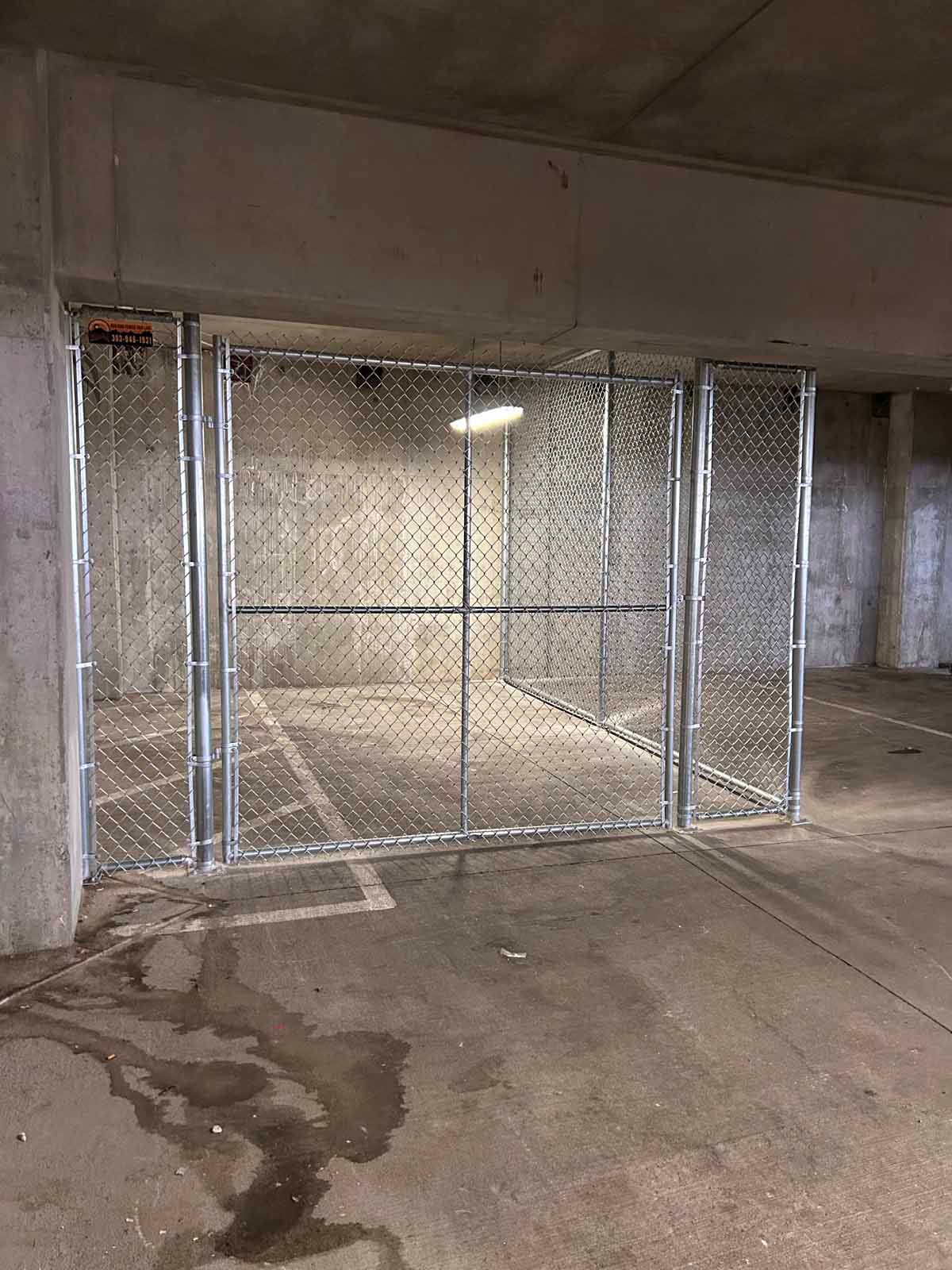There is a fence in the middle of a parking garage.