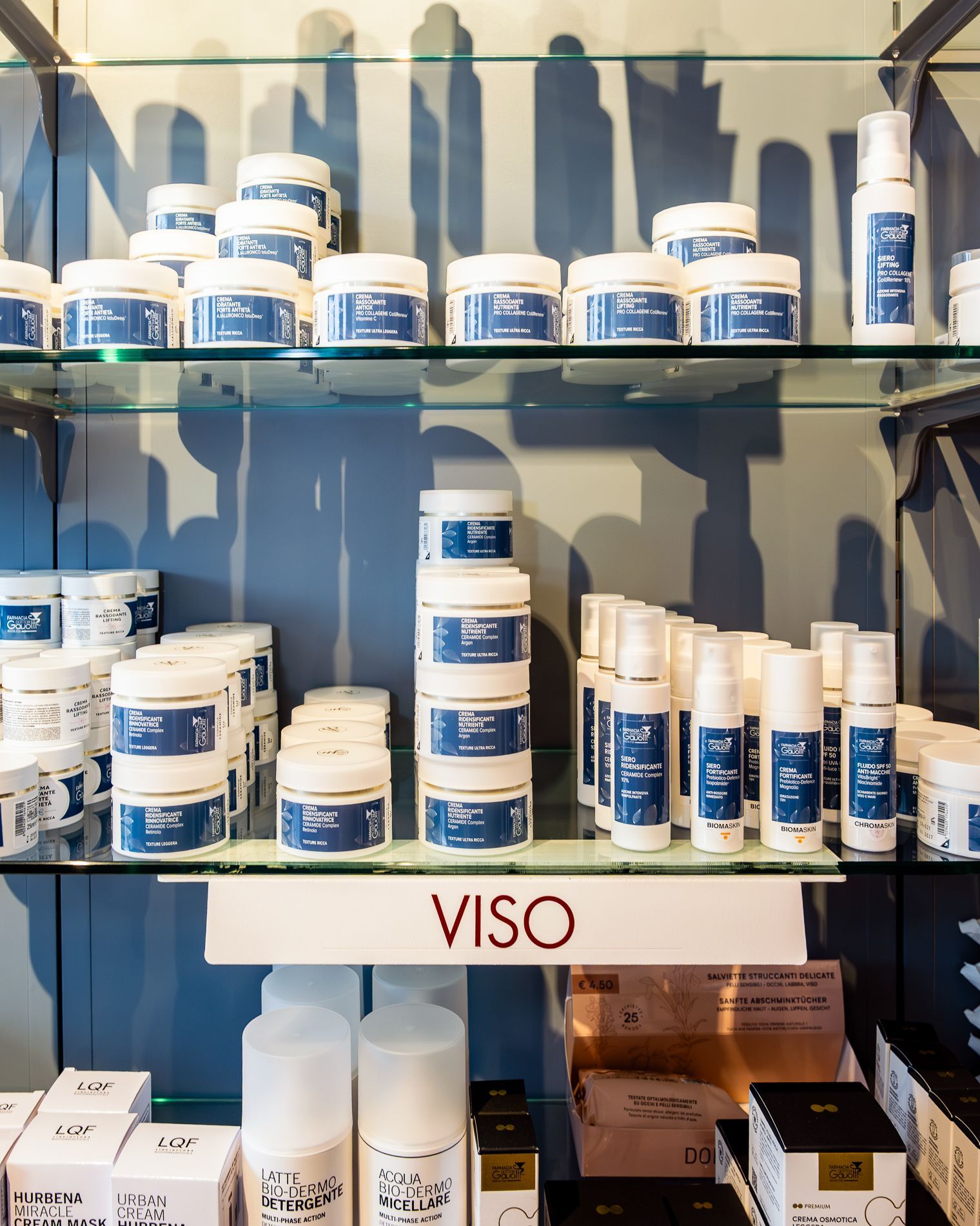 Uno scaffale pieno di bottiglie e barattoli con un cartello che dice viso