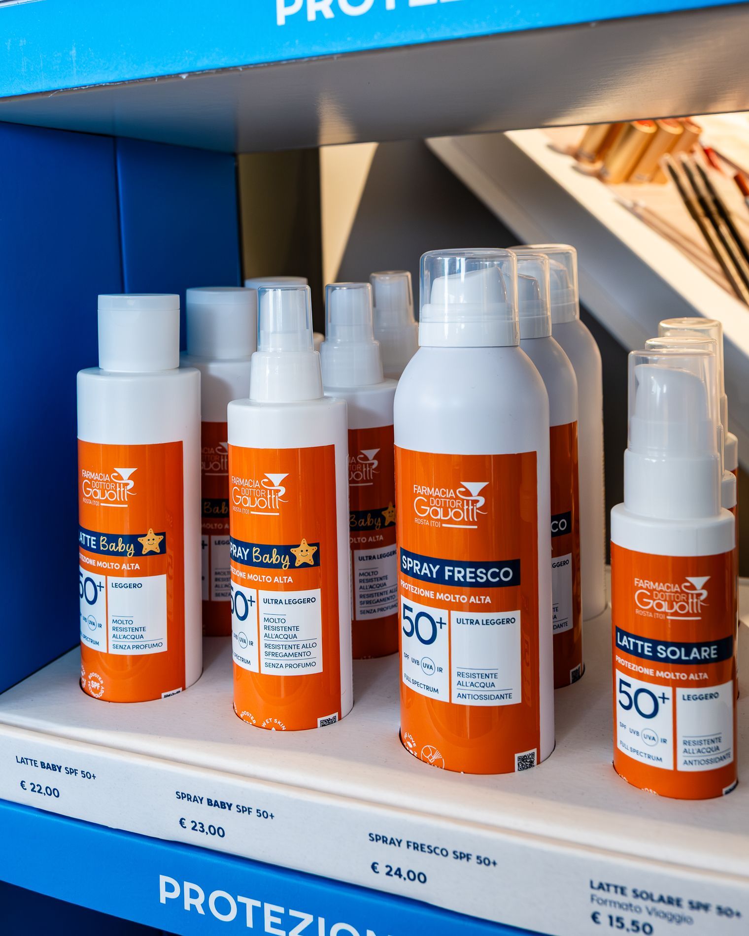 Diverse bottiglie di crema solare sono allineate su uno scaffale