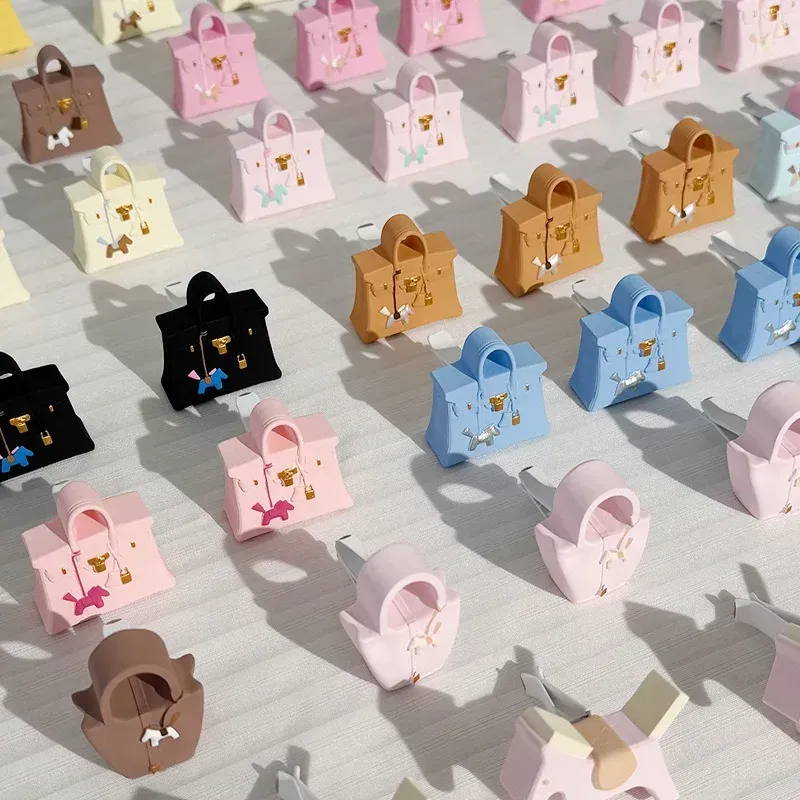 A bunch of different colored handbags are lined up on a table