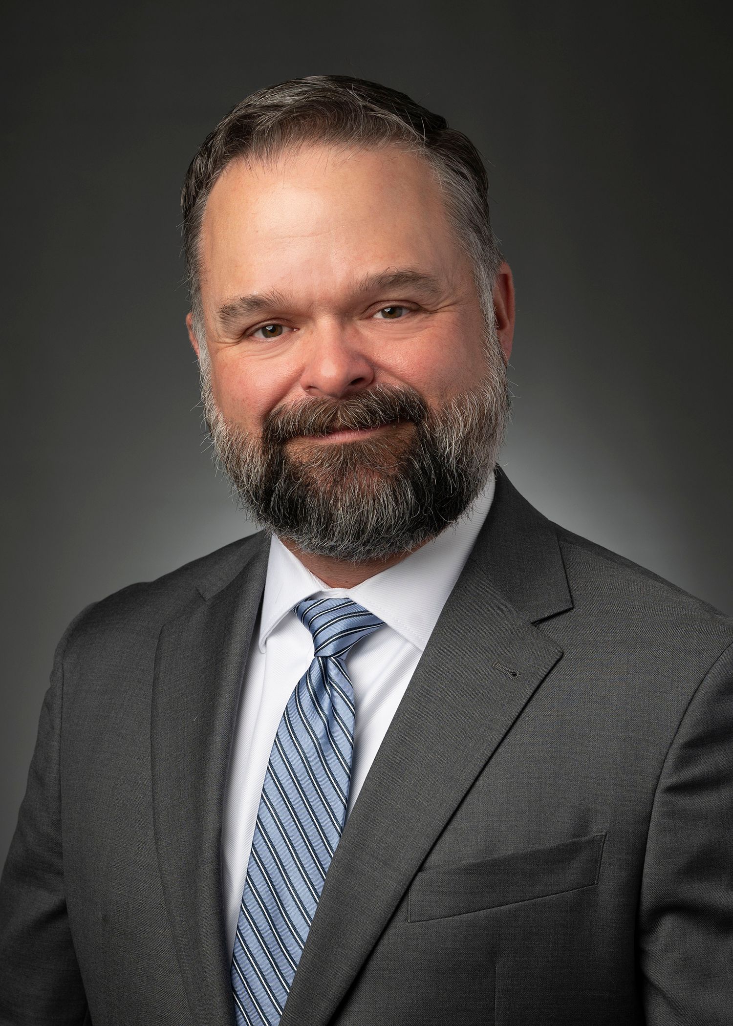 A group of men are standing around looking at a tablet.