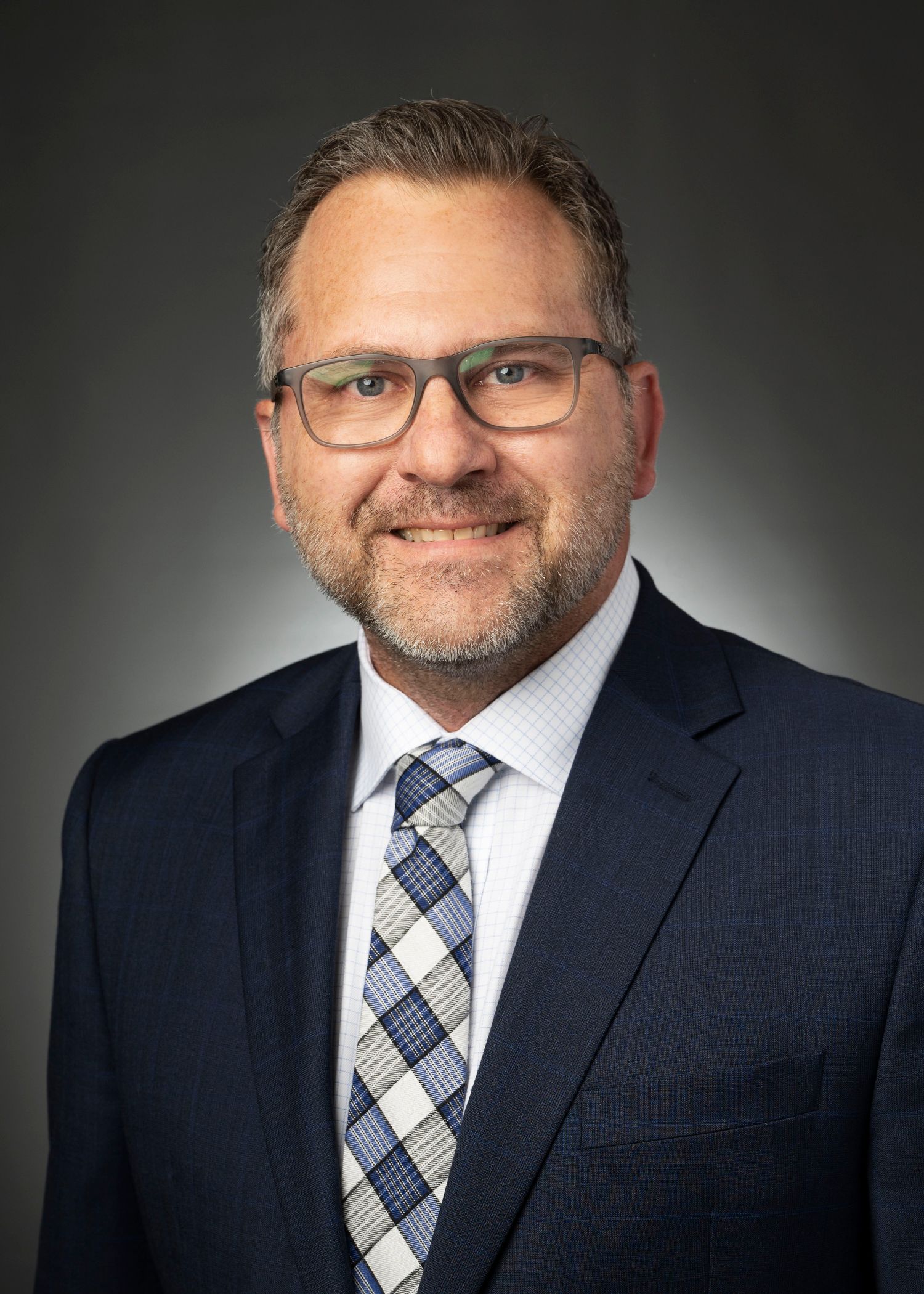 A group of men are standing around looking at a tablet.