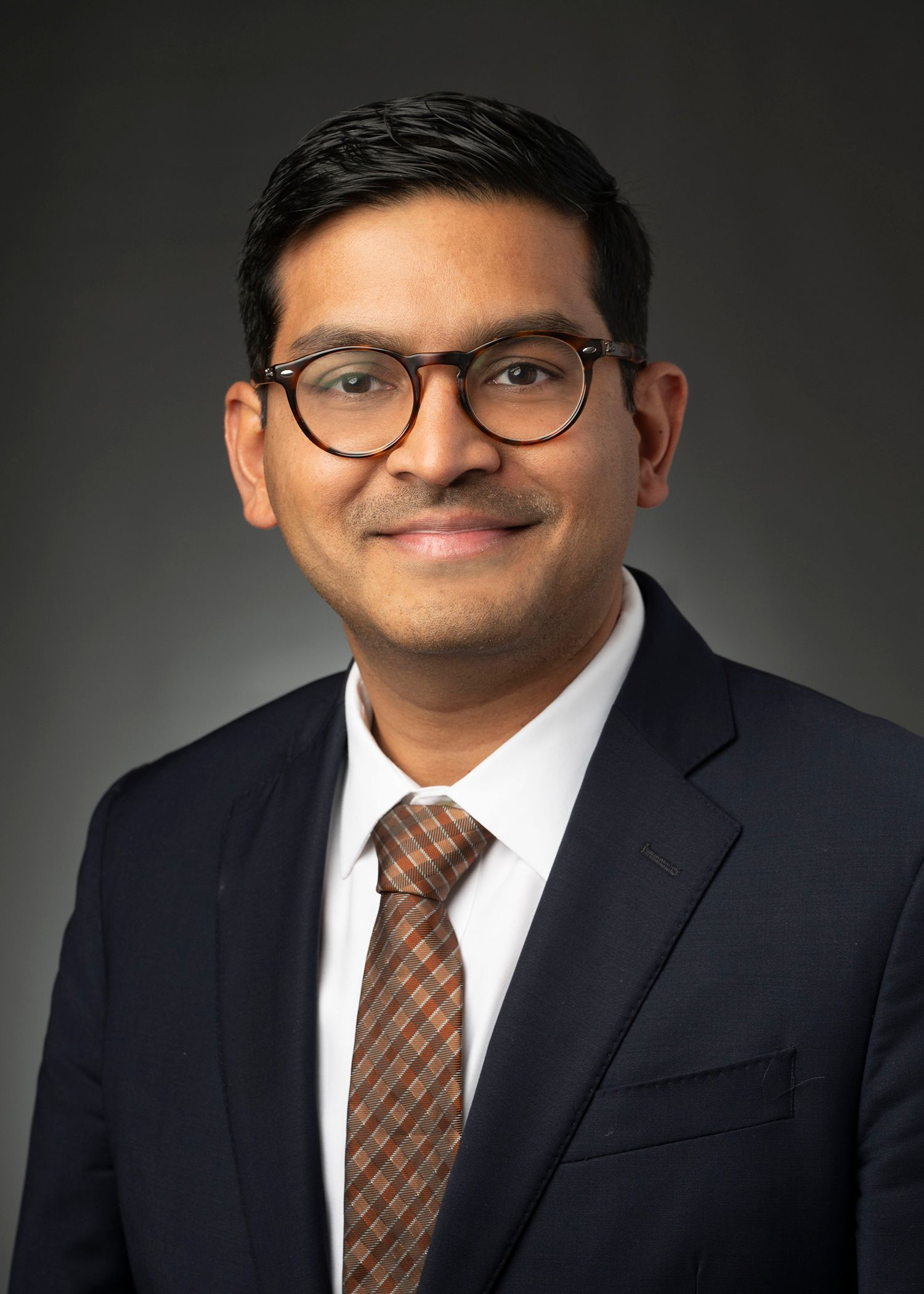 A group of men are standing around looking at a tablet.