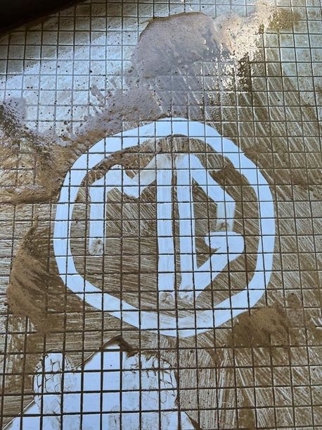 A dirty tile floor with a white circle in the middle.