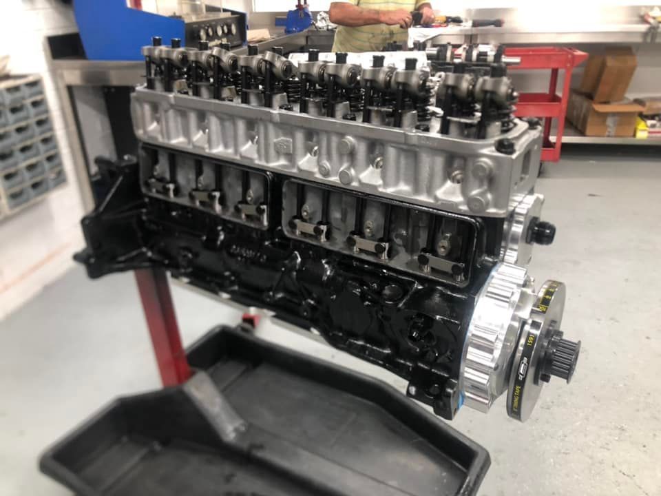 A car engine is sitting on a stand in a garage.