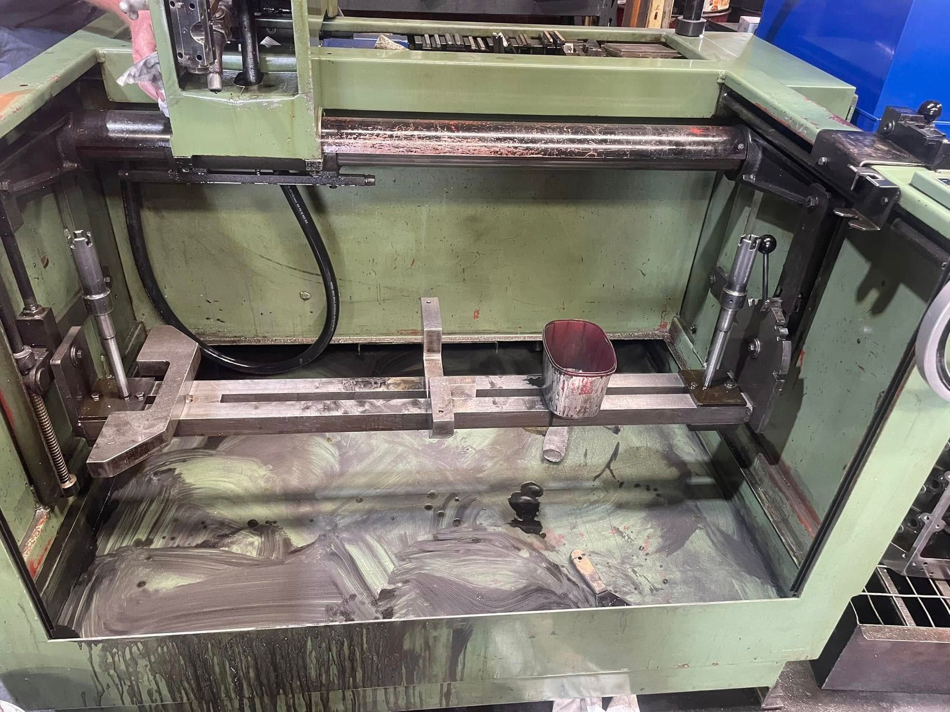 A green machine is sitting on top of a table in a factory.