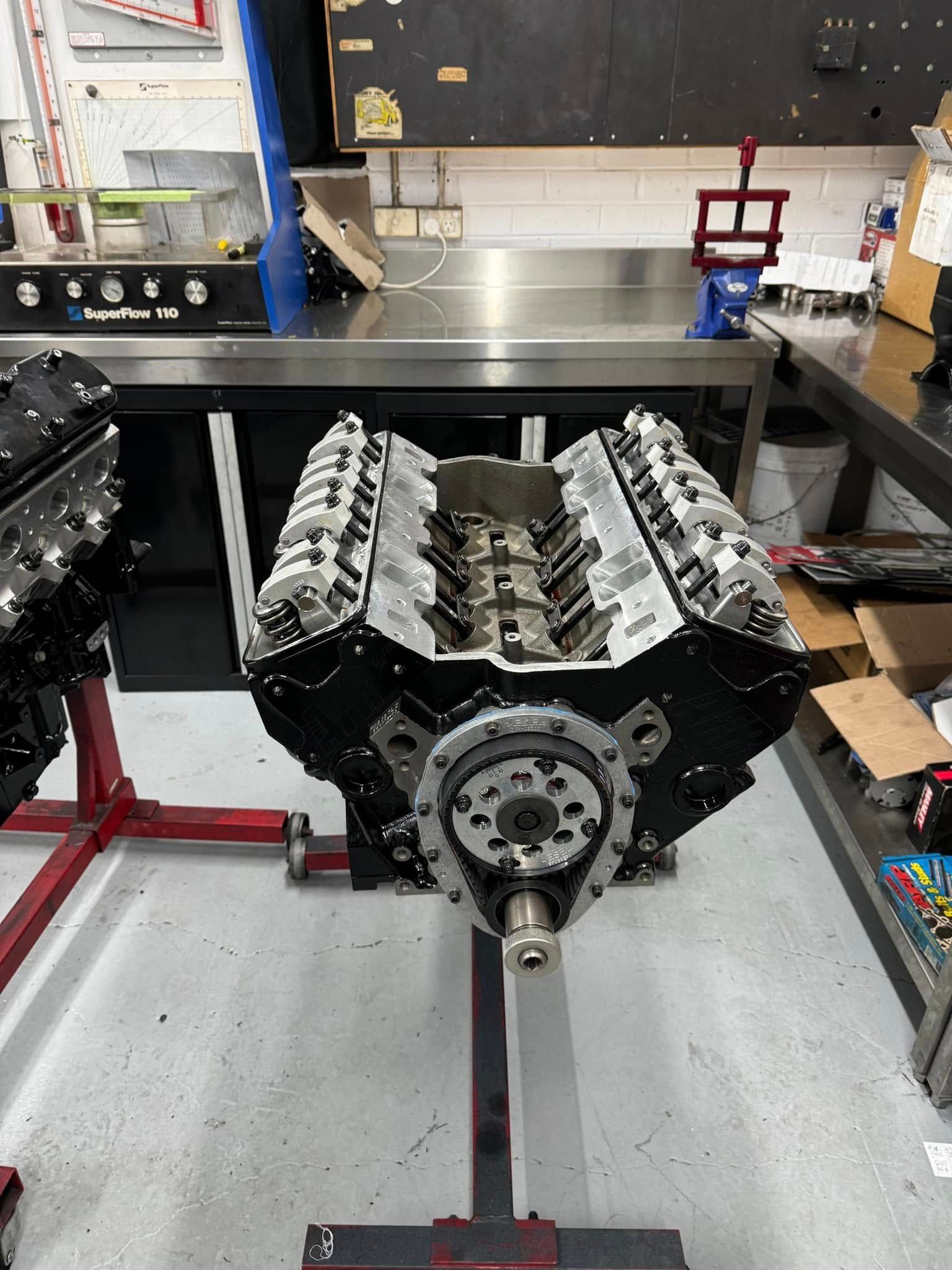 A large engine is sitting on a stand in a garage