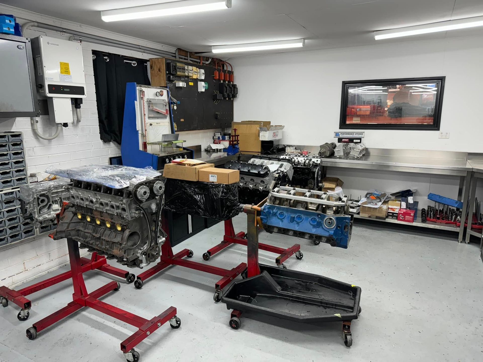 A car engine is sitting on a stand in a garage.