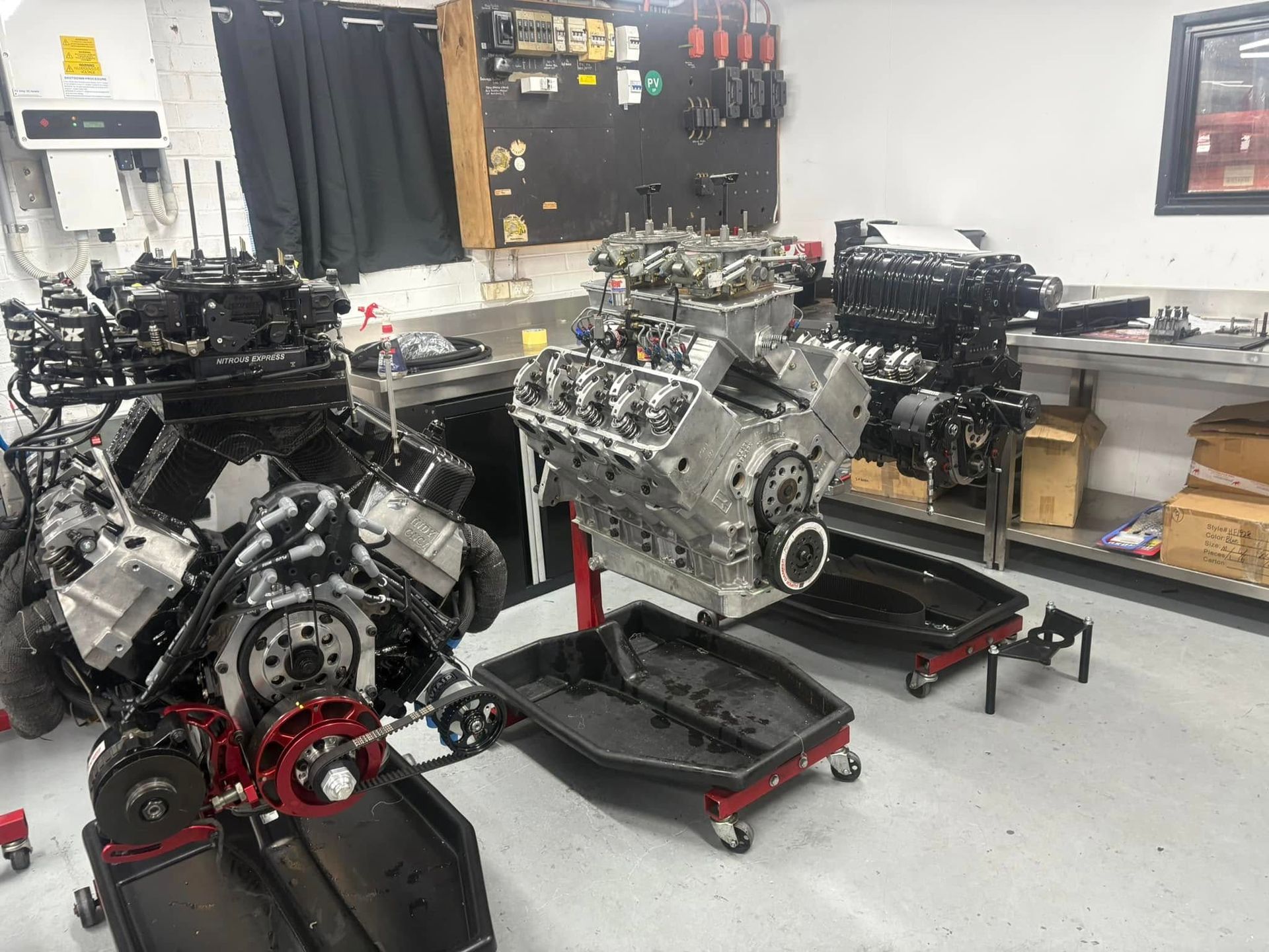 Two engines are sitting on a stand in a garage.