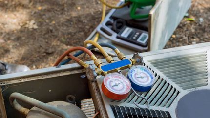 HVAC gauges connected to an air conditioning unit for servicing.