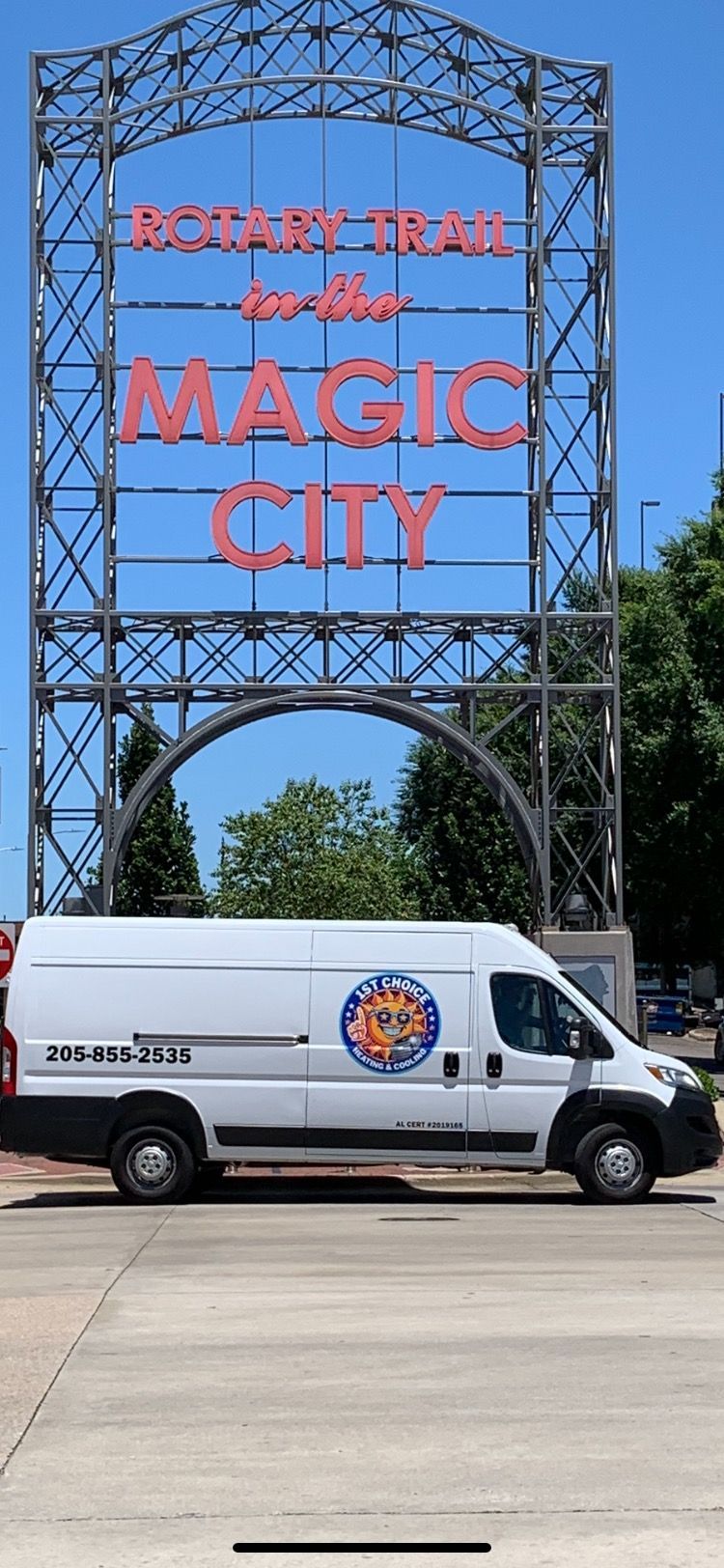 White van parked in front of the Birmingham, Alabama, Magic City sign. Blue sky background.