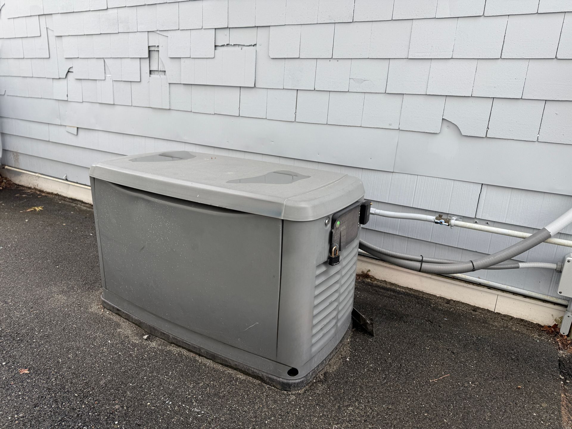 A home standby generator installed in the backyard of a house.
