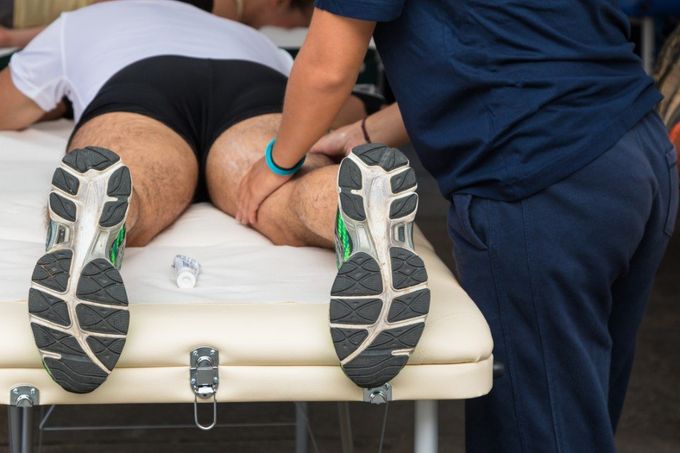 Un uomo è sdraiato su un lettino mentre riceve un massaggio.