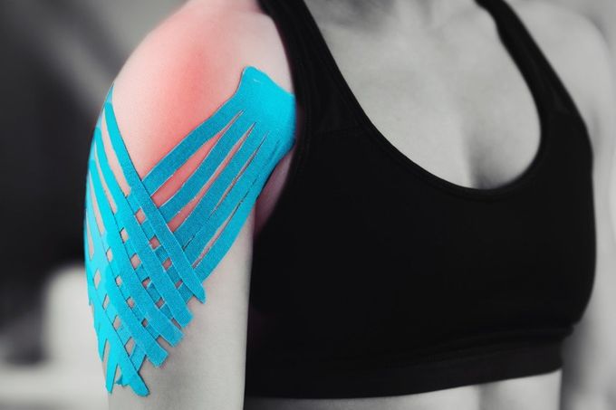 Una donna indossa del nastro kinesiologico sulla spalla.