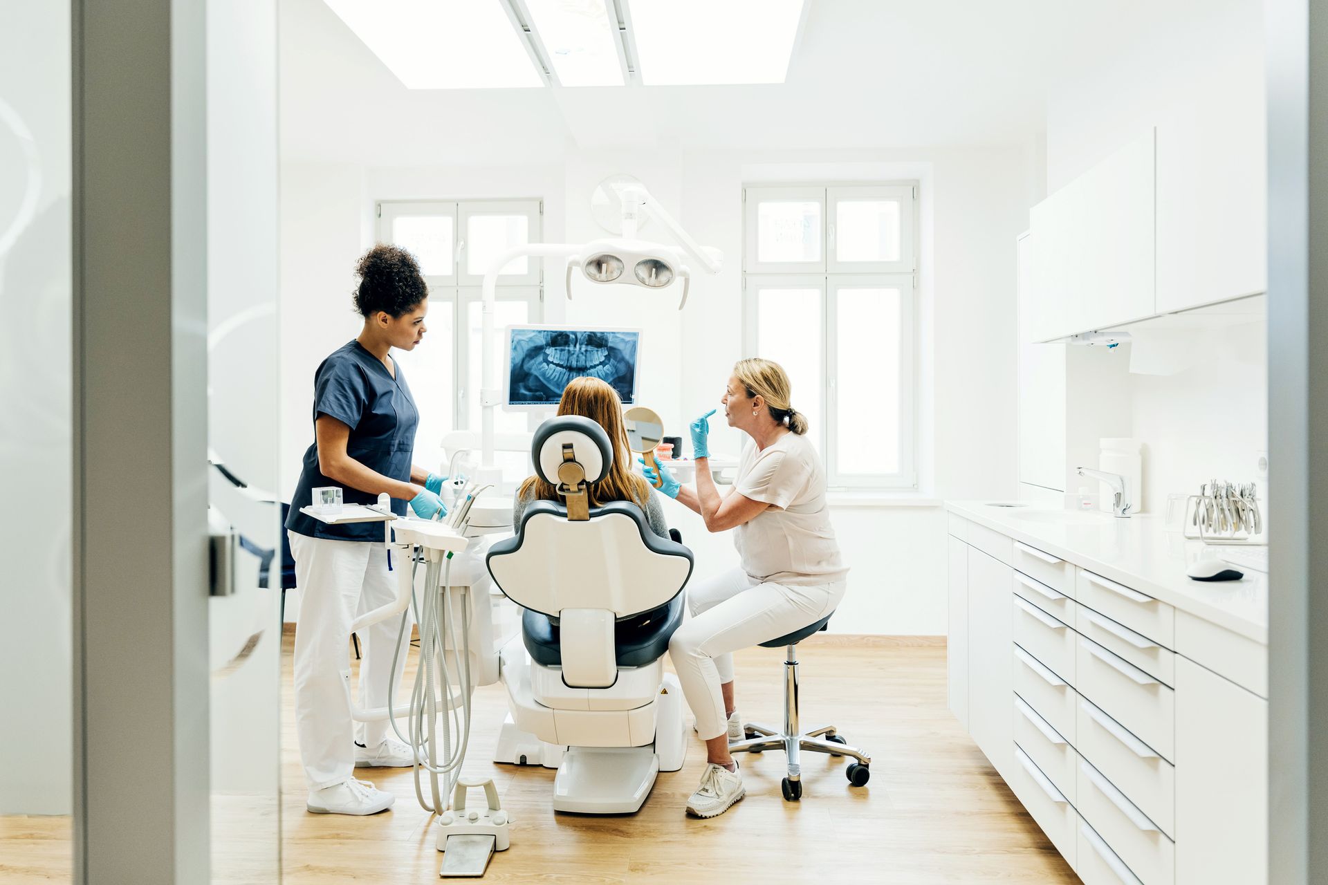 Orthodontist Showing Patient sitting on chair an X-Ray Of Teeth In Surgery