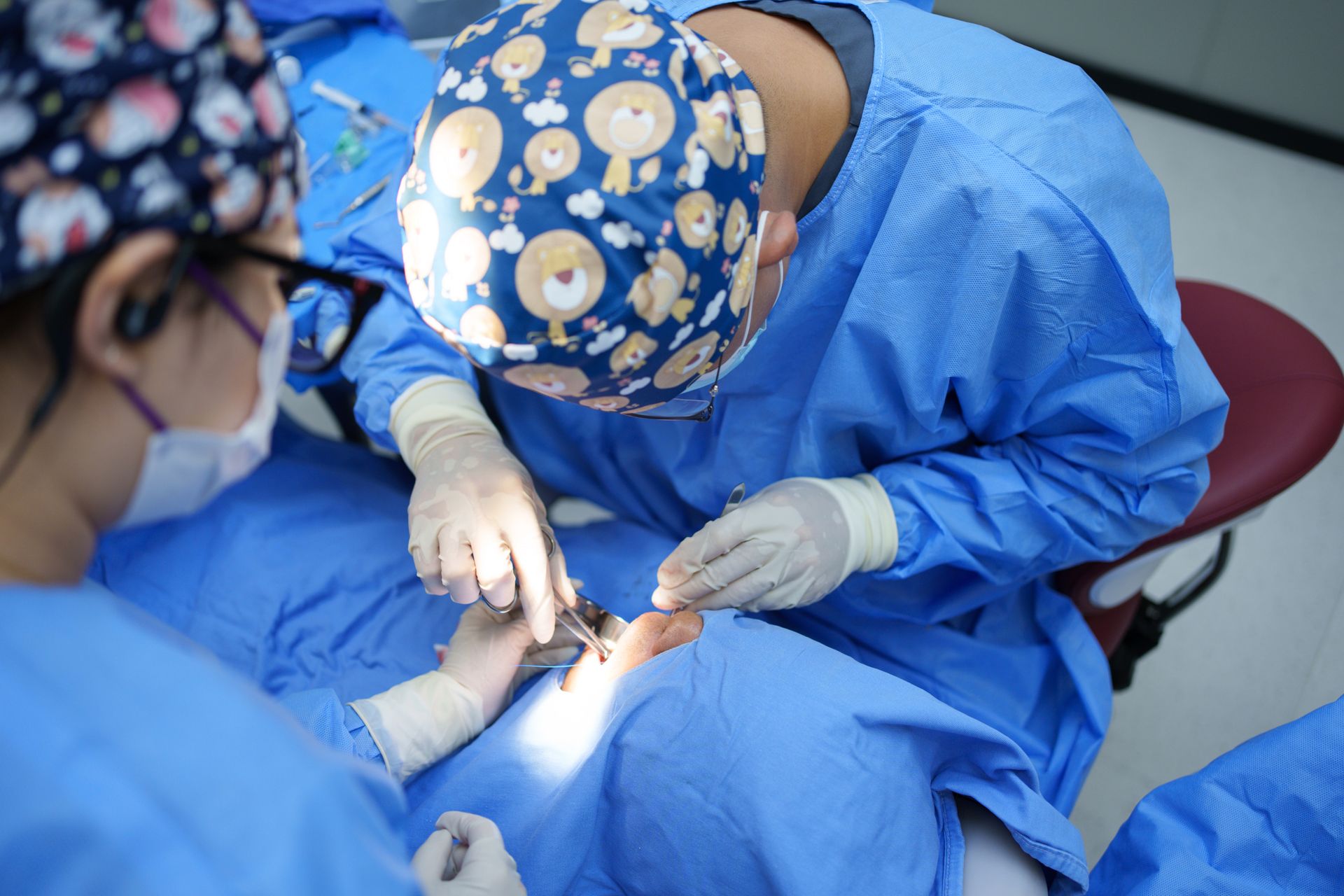 A team of doctors performing dental implant surgery.